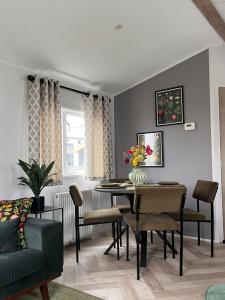 a living room with a dining room table and chairs at B&B Voor De Zee in Westerland