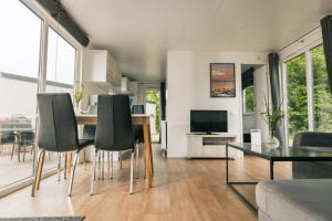 a living room with a table and chairs and a television at Storkesøen Ribe Holiday Cottages and Apartments in Ribe