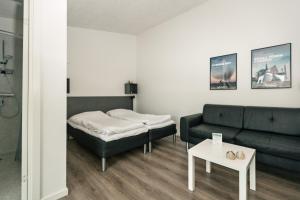 a living room with a couch and a bed at Storkesøen Ribe Holiday Cottages and Apartments in Ribe