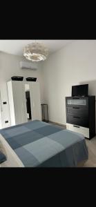 a bedroom with a blue bed and a dresser at Siracusa Vacanze in Syracuse