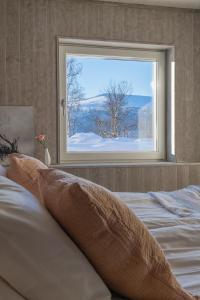 a bedroom with a bed with a window and snow at Röstavallens Högfjällshotell in Tänndalen +10 photos