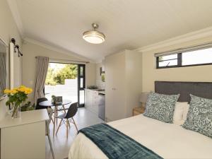 a bedroom with a bed and a table and a kitchen at Catalyst Guest House in Cape Town