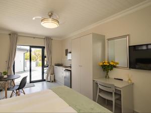 a bedroom with a bed and a table and a kitchen at Catalyst Guest House in Cape Town