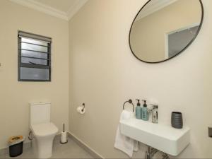 a white bathroom with a sink and a mirror at Catalyst Guest House in Cape Town +54 photos