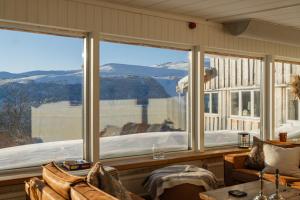 a room with a large window with a view of a snow covered mountain at Röstavallens Högfjällshotell in Tänndalen