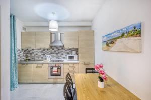 a kitchen with a wooden table and a dining room at 1-Bed Suite Near Spinola Bay in Paceville