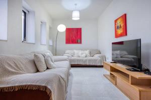 a living room with a couch and a tv at 1-Bed Suite Near Spinola Bay in Paceville