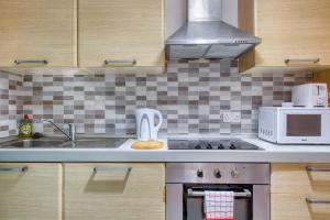 a kitchen with a sink and a microwave at 1-Bed Suite Near Spinola Bay in Paceville +12 photos