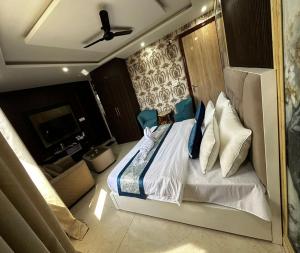 a bedroom with a bed with pillows and a couch at Minta Hotel and Banquet in Noida