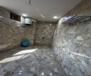 a bathroom with a stone wall and a blue toilet at Minta Hotel and Banquet in Noida +50 photos