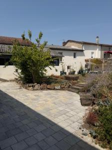 a yard with a stone walkway in front of a house at Chambre Le Colibri in Lezoux
