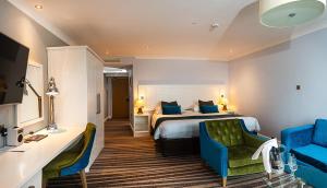 a hotel room with a bed and a blue chair at St George's Hotel - Llandudno in Llandudno