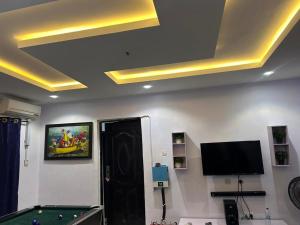 a room with a pool table and a tv at Apartment in Alakuko in Akinde