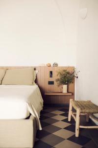 a bedroom with a bed and a bench and a table at Masseria Pietra e Terra in Carovigno +30 photos