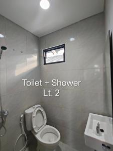 a bathroom with a toilet and a sink at Park Serpong Type XYZ Cluster Charm in Carangpulang