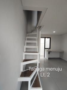 a white staircase in a white room at Park Serpong Type XYZ Cluster Charm in Carangpulang +2 photos
