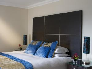 a bedroom with a large bed with blue pillows at Rocpool Reserve Hotel & Restaurant in Inverness