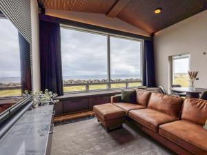 a living room with a couch and a large window at Bay View Villa in Gardur