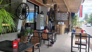 a restaurant with tables and chairs with a child sitting at it at Park Inn Boutique and Hostel in Kampot