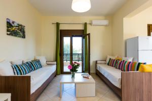 a living room with two couches and a refrigerator at Eleonas Apartments in Prinés