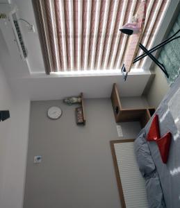 a room with a window and a clock on the floor at Vaiga Heavens - 1 BHK Apartment, 500 m to temple in Guruvāyūr
