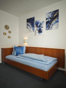 a bed in a room with paintings on the wall at Pension Villa Sarah in Bad Dürrheim