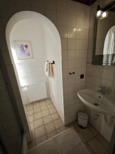 a white bathroom with a sink and a mirror at Pension Villa Sarah in Bad Dürrheim +11 photos