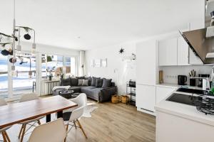 a kitchen and living room with a table and chairs at Schneerosenblüte Steibis mit O Plus in Oberstaufen