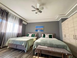 a bedroom with two beds and a ceiling fan at Villa Sun Budva in Budva