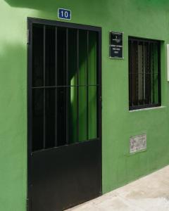 a green building with a black door with a sign on it at Prieto Picudo - Harbor's Light in Villajoyosa
