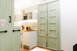 a kitchen with white cabinets and a green door at Prieto Picudo - Harbor's Light in Villajoyosa