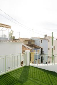 a balcony with green grass on a white building at Prieto Picudo - Harbor's Light in Villajoyosa +8 photos