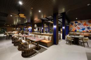 a restaurant with tables and chairs and a bar at La Solaya Khao Lak in Khao Lak