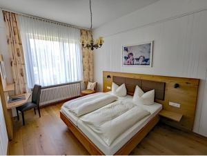 a bedroom with a large bed and a desk at Hotel Fidelitas in Bad Herrenalb