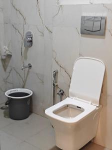 a bathroom with a toilet and a trash can at Bellevue Retreat in Alībāg +6 photos
