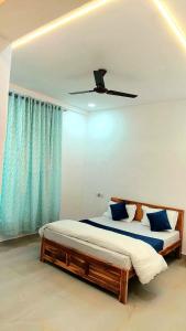 a bedroom with a bed and a ceiling fan at Bellevue Retreat in Alībāg