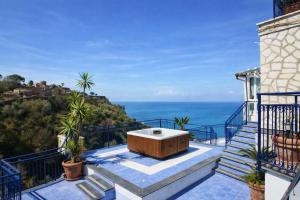 a hot tub on a balcony with a view of the ocean at Hotiday Vico Equense in Vico Equense