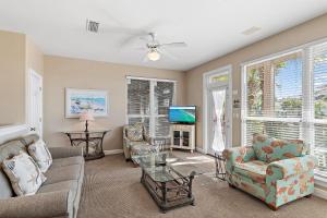 a living room with a couch and chairs and a tv at Destiny Beach Villas #9A in Destin