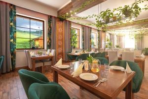 a restaurant with wooden tables and green chairs at Kompleks Zagroń Istebna in Istebna