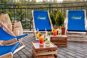 two chairs and two cocktails on a patio at Kompleks Zagroń Istebna in Istebna
