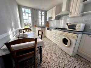 a kitchen with a table and a washing machine at Maison jeanborde in Serreslous-et-Arribans