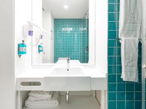 a bathroom with a white sink and blue tiles at LSA Restauradores by Numa in Lisbon