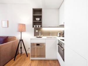 a white kitchen with a sink and a couch at LSA Restauradores by Numa in Lisbon