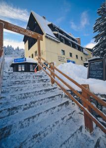 un edificio con nieve en las escaleras delante en Straszny Dwór en Zieleniec