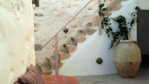 a staircase with a vase next to a stone wall at En Patmo Holiday Home in Patmos