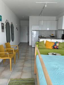 a living room with a green bed and a kitchen at Krasas Beach in Larnaca