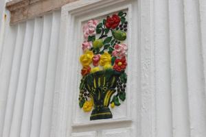 ein Fenster mit einer Blumenvase an der Wand in der Unterkunft Puzzle Suites B&B in Figueira da Foz