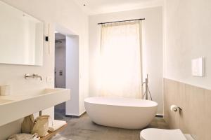 a white bathroom with a large tub and a sink at Masseria Pietra e Terra in Carovigno