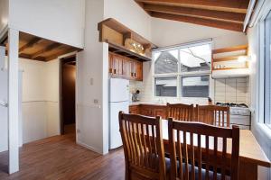 a kitchen with a table and chairs and a refrigerator at Gundy Lodge in Dinner Plain