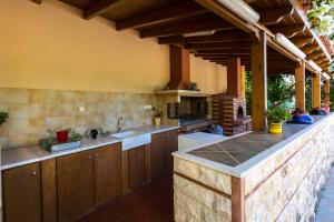 a kitchen with wooden cabinets and a counter top at Eleonas Apartments in Prinés